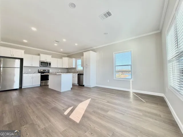 a kitchen with granite countertop a stove and a wooden floors