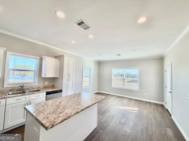 a kitchen with stainless steel appliances cabinets and wooden floor