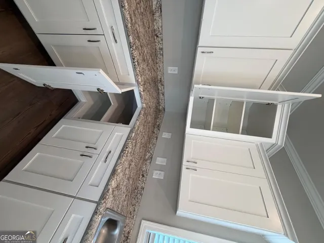 a kitchen with large window cabinets and wooden floor