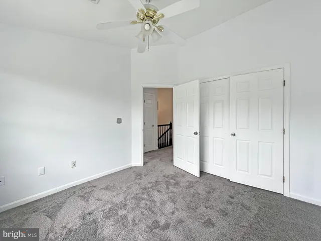 a view of an empty room and chandelier fan