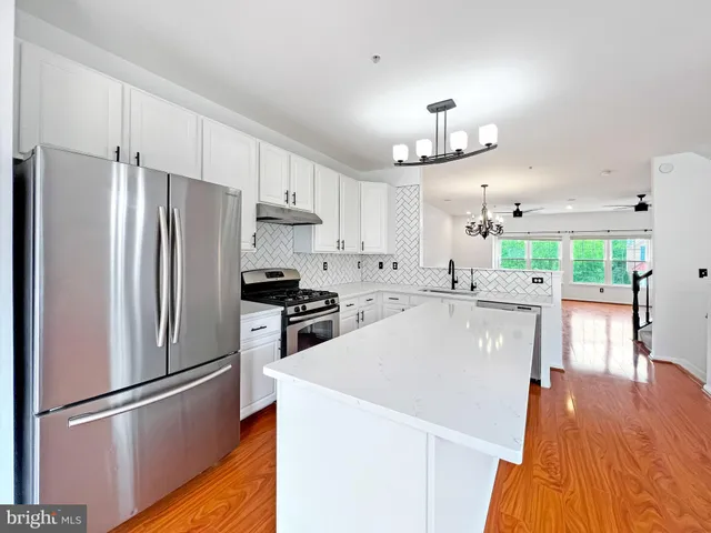 a kitchen with stainless steel appliances a refrigerator sink and microwave