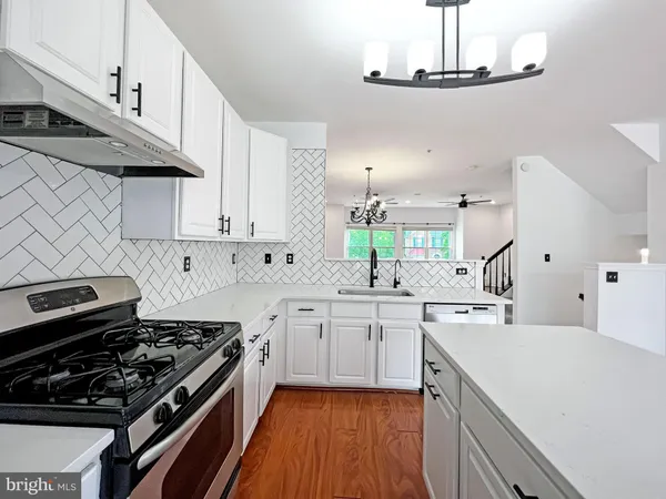a kitchen with stainless steel appliances a sink a stove and cabinets