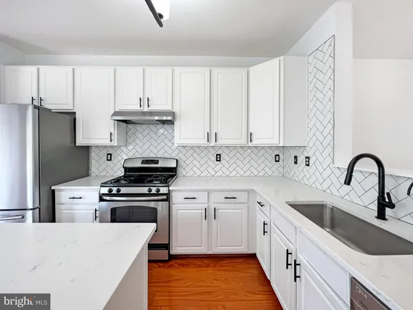 a kitchen with stainless steel appliances granite countertop a stove a sink dishwasher and a refrigerator