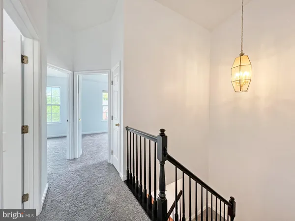 a view of a hallway with wooden floor and chandelier