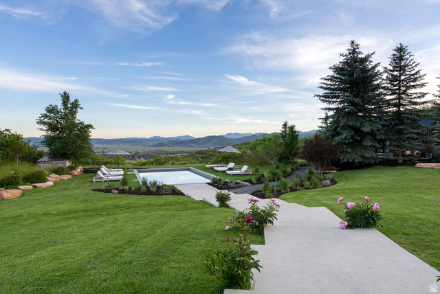 5971 Maple Ridge Trail Oakley, UT 84055 - Photo 9 of 43 Spacious lawn with a rectangular swimming pool, concrete patio, and mature evergreen trees