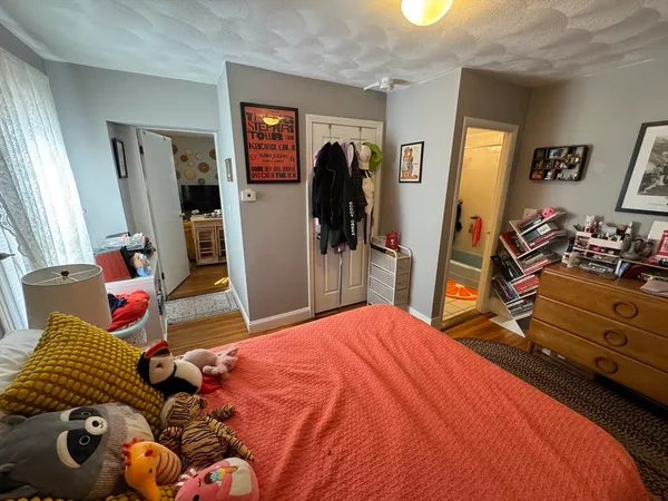 a bedroom with bed and wooden floor