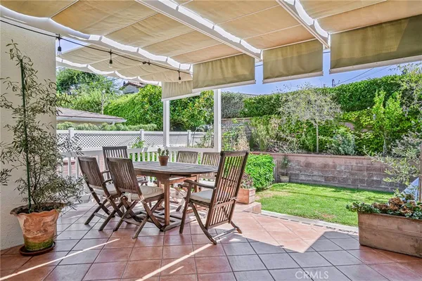 a view of a patio with table and chairs potted plants with wooden floor and fence
