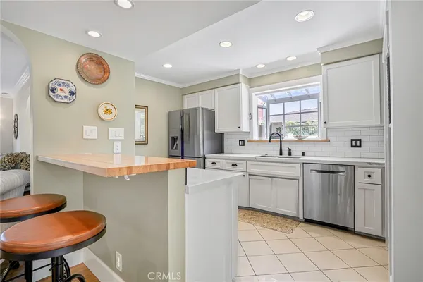 a kitchen with stainless steel appliances a sink and a refrigerator