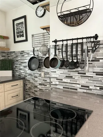 a kitchen with a stove and a white wooden cabinets