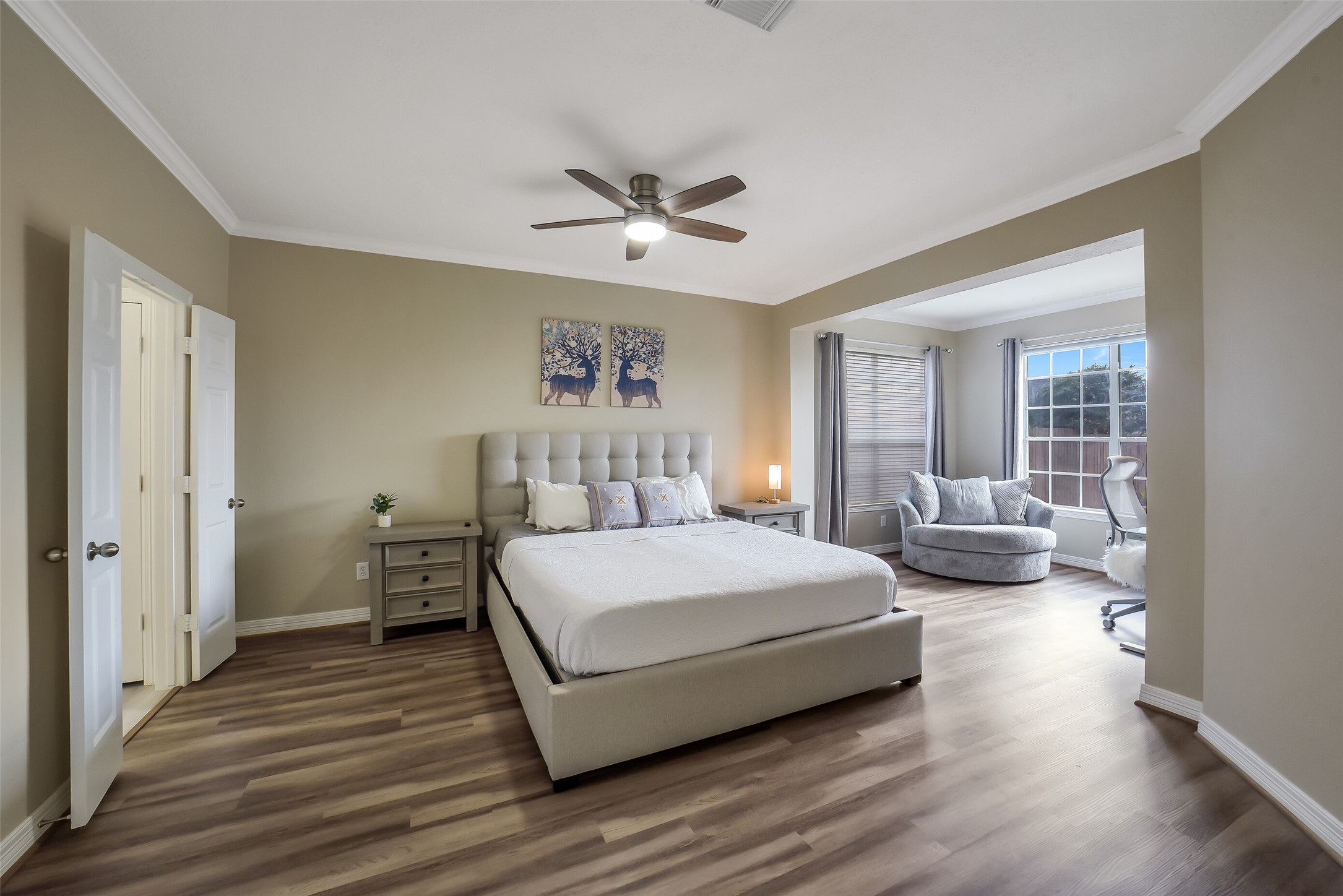 24403 Falcon Point Drive Katy, TX 77494 - Photo 14 of 32 Spacious primary bedroom retreat featuring a separate seating area, sleek vinyl plank flooring and large windows that fill the room with natural light.