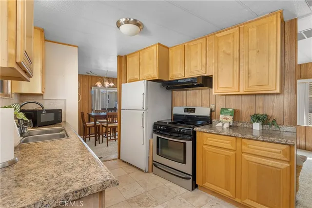 a kitchen with stainless steel appliances granite countertop a stove a sink dishwasher and a refrigerator