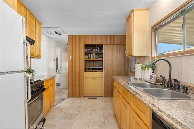 a kitchen with granite countertop a sink stove and cabinets