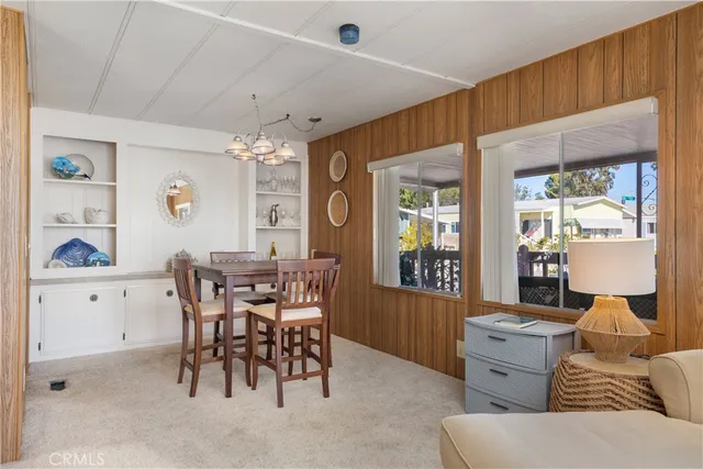 a living room with furniture a chandelier and a large window