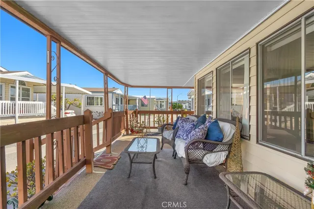 a balcony with chairs and glass door