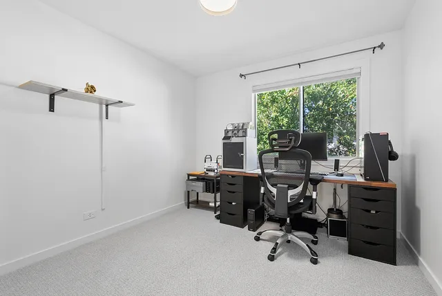 a view of a workspace with furniture and a window