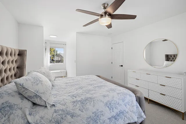 a bedroom with a large bed and a chandelier