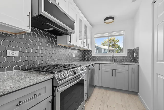 a kitchen with stainless steel appliances granite countertop a sink stove and cabinets