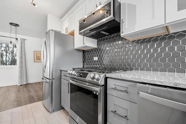 a kitchen with granite countertop cabinets stainless steel appliances and wooden floor