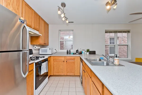 a kitchen with stainless steel appliances granite countertop a sink a stove and refrigerator
