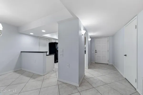 a view of a livingroom with a kitchen and a chandelier fan