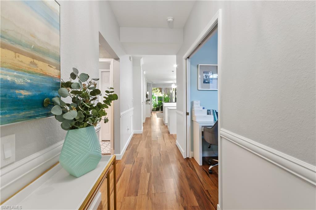 10020 Heather Lane, Unit 901 Naples, FL 34119 - Photo 13 of 34 a view of a hallway with wooden floor and a potted plant