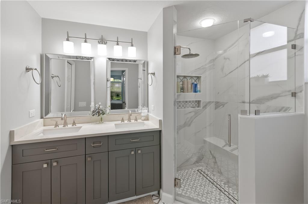 10020 Heather Lane, Unit 901 Naples, FL 34119 - Photo 15 of 34 a bathroom with a double vanity sink mirror and shower