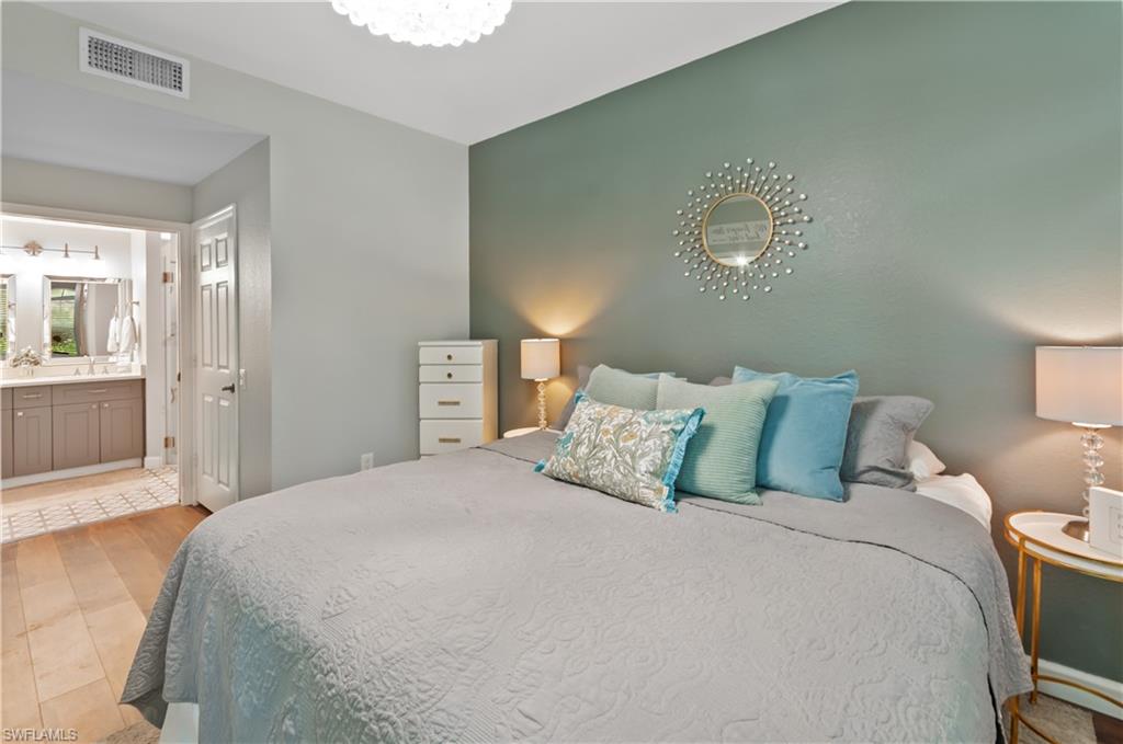 10020 Heather Lane, Unit 901 Naples, FL 34119 - Photo 18 of 34 a large bed sitting in a bedroom and a lamp