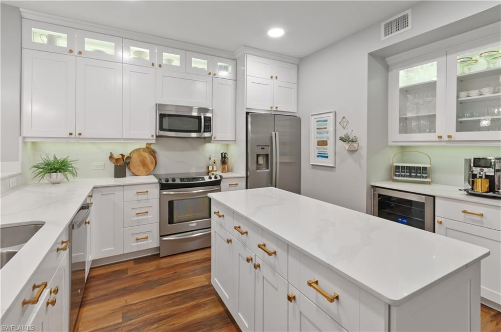 10020 Heather Lane, Unit 901 Naples, FL 34119 - Photo 22 of 34 a kitchen with a refrigerator and a stove top oven