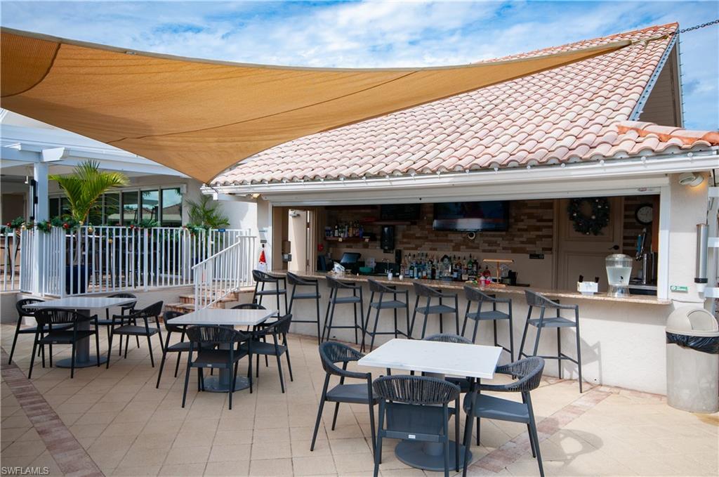 10020 Heather Lane, Unit 901 Naples, FL 34119 - Photo 26 of 34 a patio with table and chairs