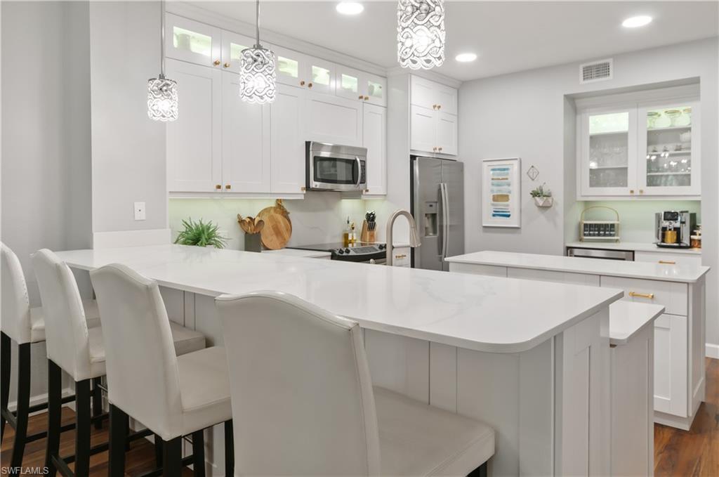 10020 Heather Lane, Unit 901 Naples, FL 34119 - Photo 7 of 34 a kitchen with cabinets and stainless steel appliances