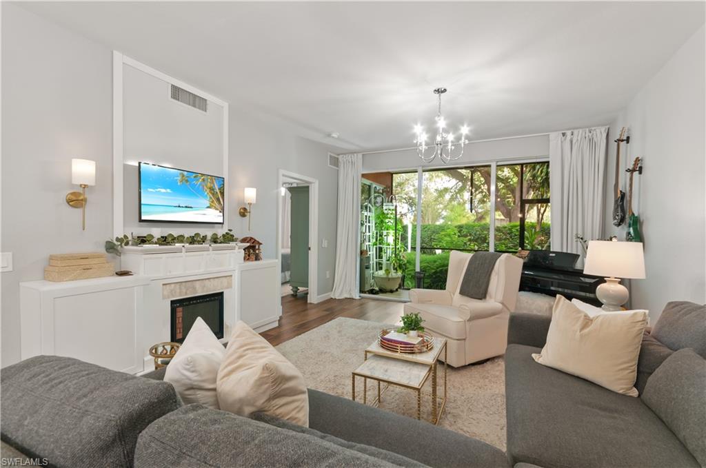 10020 Heather Lane, Unit 901 Naples, FL 34119 - Photo 8 of 34 a living room with furniture a fireplace and a large window