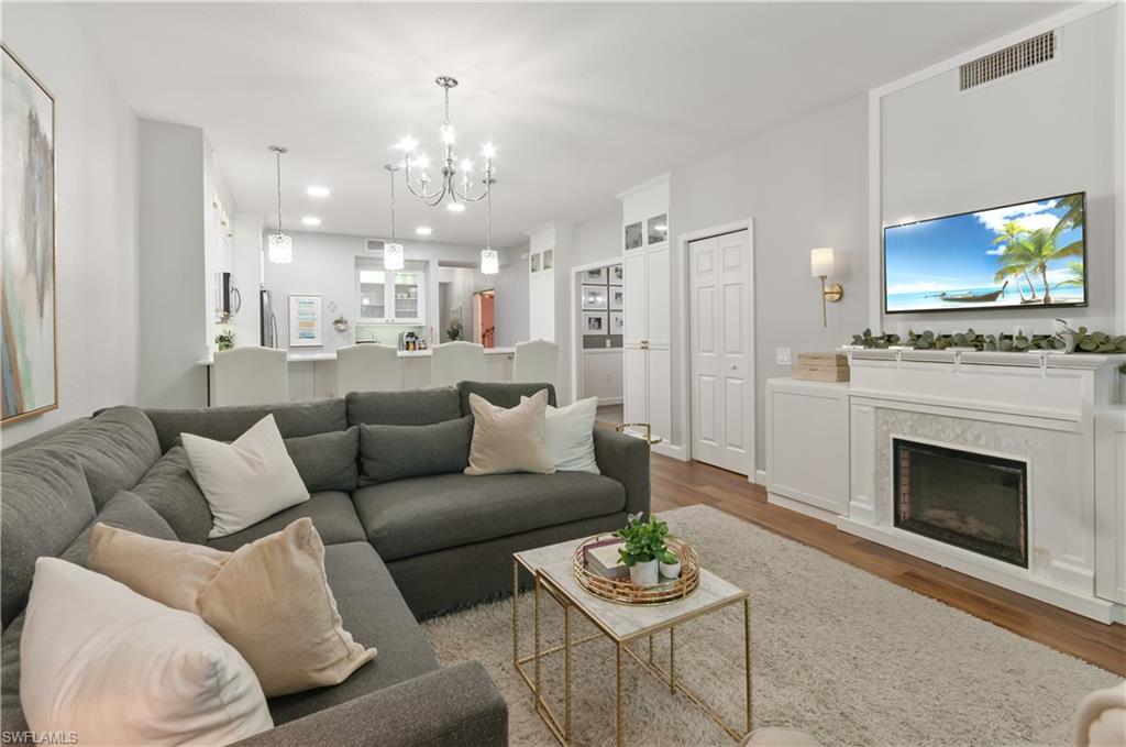 10020 Heather Lane, Unit 901 Naples, FL 34119 - Photo 9 of 34 a living room with furniture a fireplace and a flat screen tv
