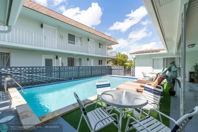 a view of a patio with table and chairs with wooden floor and fence