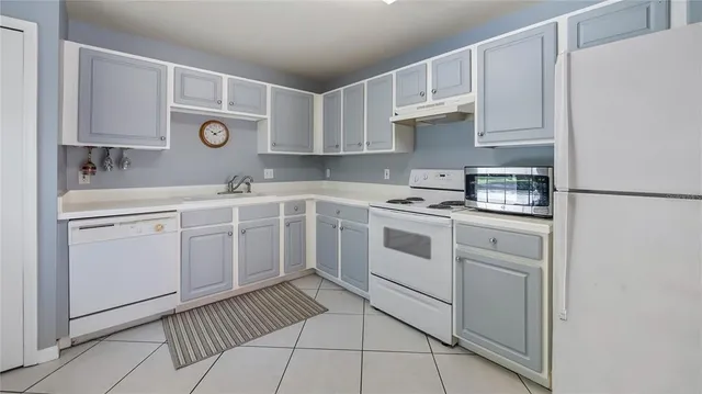 a kitchen with white cabinets and white appliances