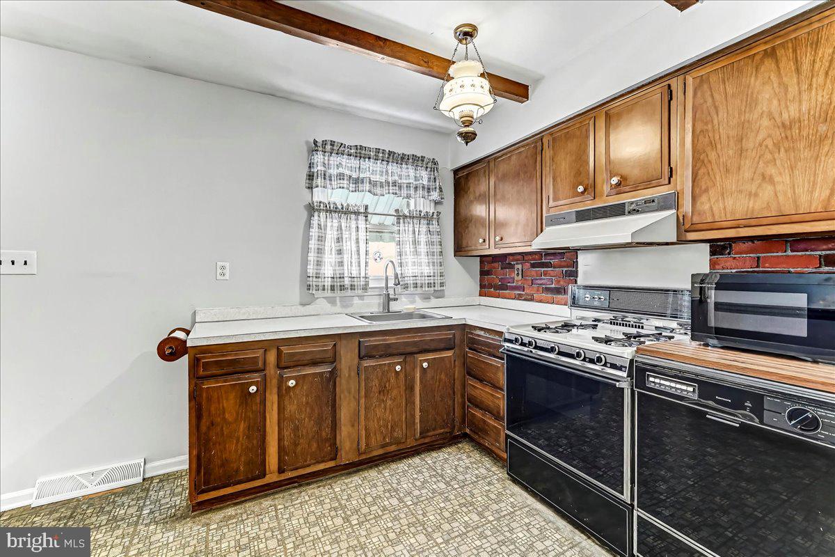 123 Reybold Drive Delaware City, DE 19706 - Photo 11 of 30 a kitchen with stainless steel appliances granite countertop a sink a stove a refrigerator cabinets and wooden floor