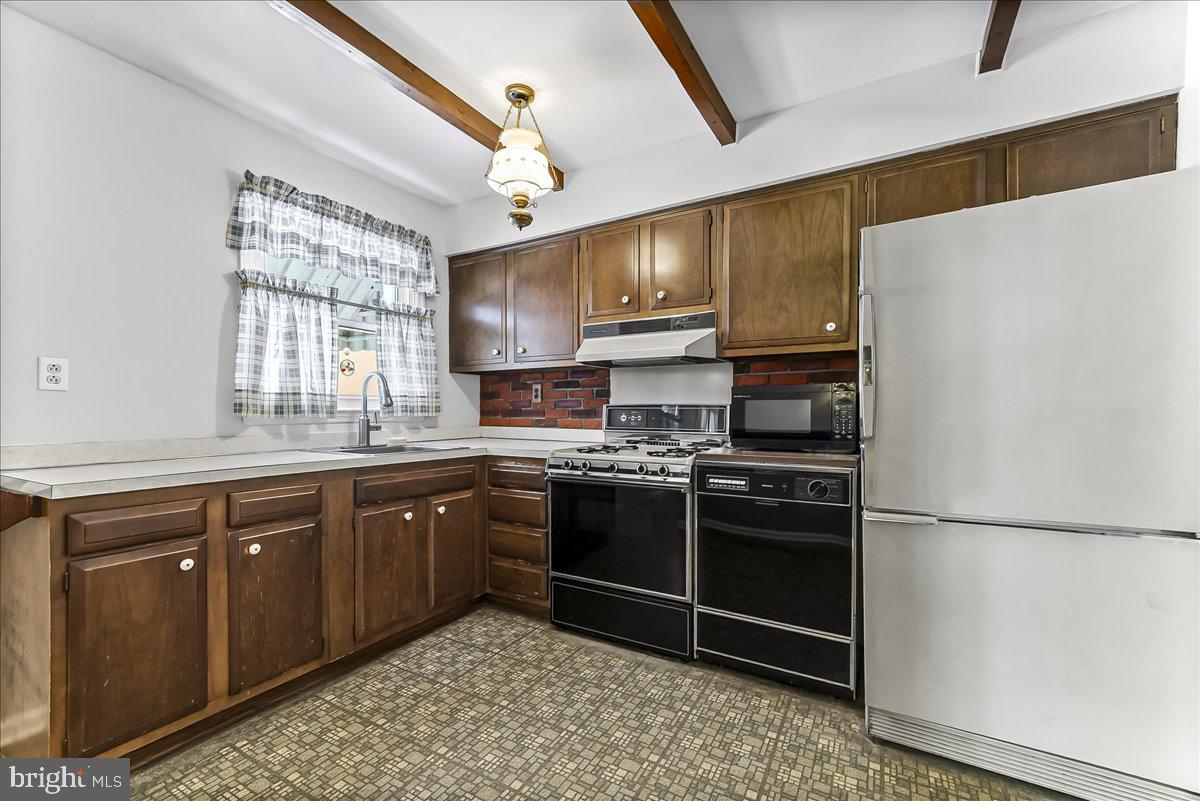 123 Reybold Drive Delaware City, DE 19706 - Photo 9 of 30 a kitchen with stainless steel appliances granite countertop a refrigerator a sink dishwasher a stove with white cabinets and wooden floor
