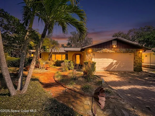an aerial view of a house with a yard and lake view