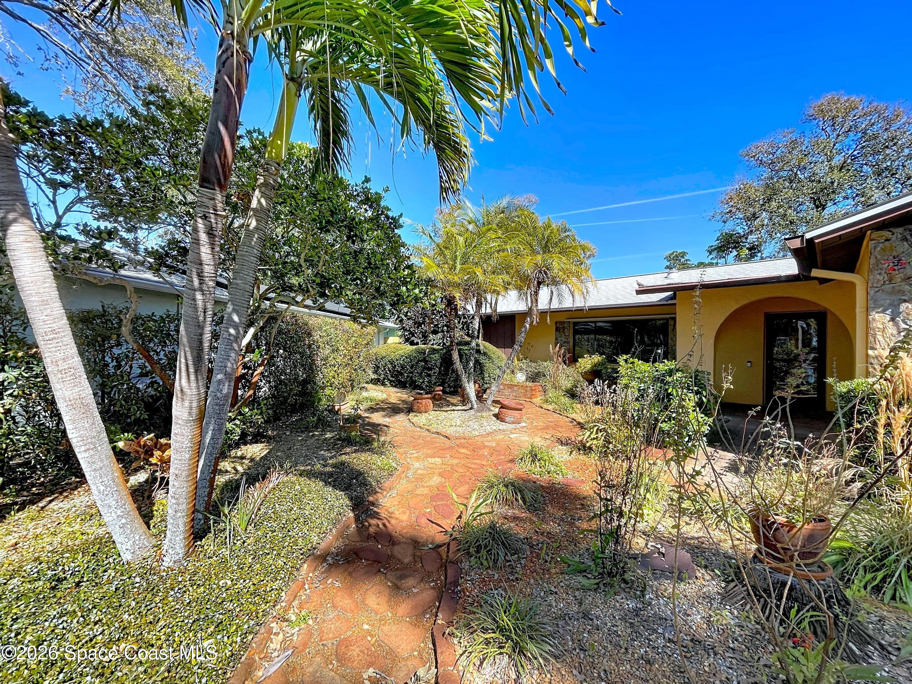 9591 128th Terrace North Largo, FL 33773 - Photo 84 of 90 a view of a backyard with plants and a large tree