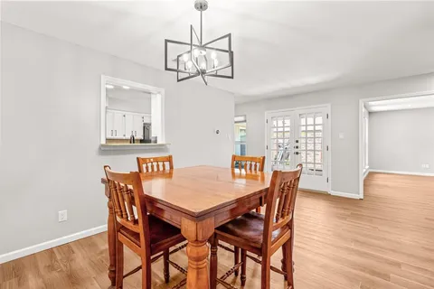 a view of a dining room with furniture a chandelier and wooden floor