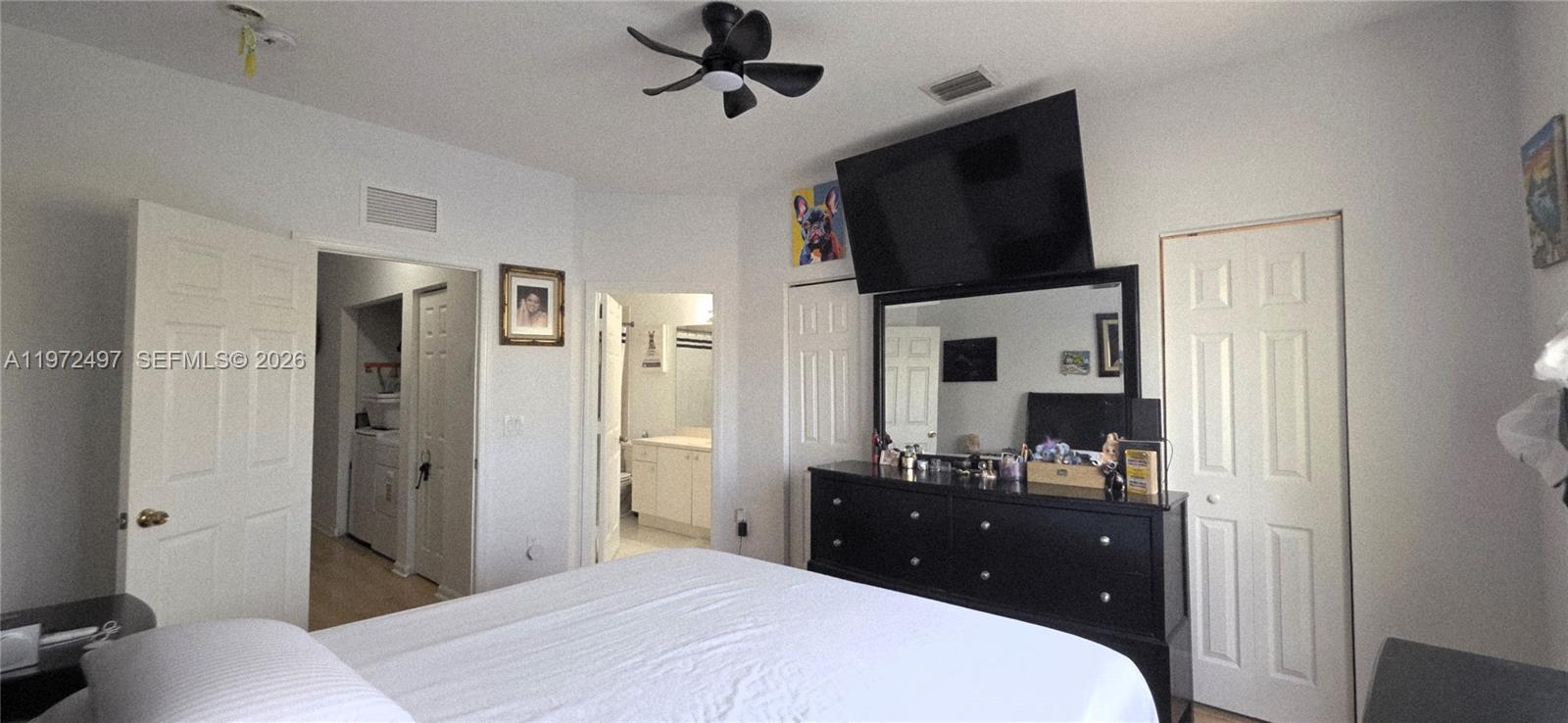 5937 Riverside Avenue Tamarac, FL 33321 - Photo 22 of 31 a bedroom with a bed and a flat tv screen on dresser