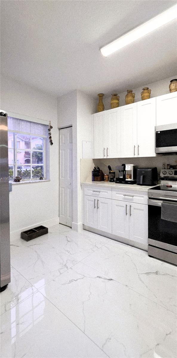 5937 Riverside Avenue Tamarac, FL 33321 - Photo 6 of 31 a kitchen with granite countertop a stove top oven sink and cabinets