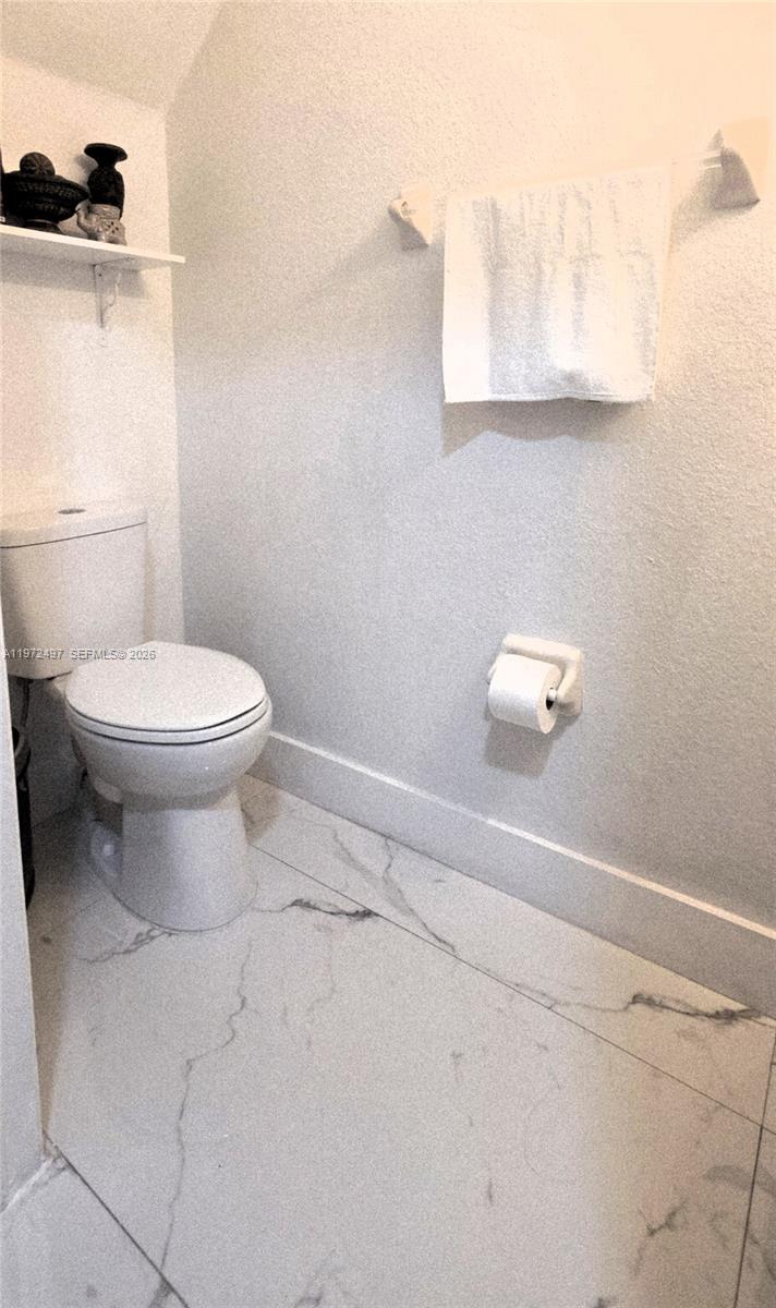 5937 Riverside Avenue Tamarac, FL 33321 - Photo 10 of 31 a bathroom with a toilet and a mirror