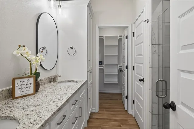 a spacious bathroom with a granite countertop double vanity sink and a mirror