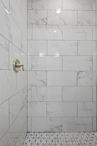 a view of a hallway with wooden floor and a bathroom