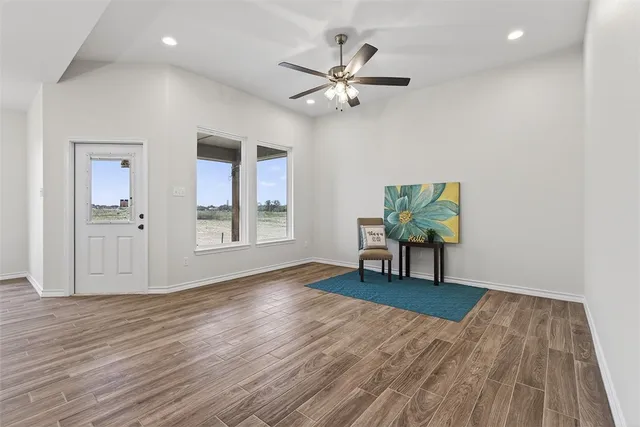 a view of a livingroom with wooden floor and a ceiling fan