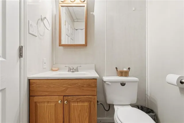 a bathroom with a toilet a sink and mirror