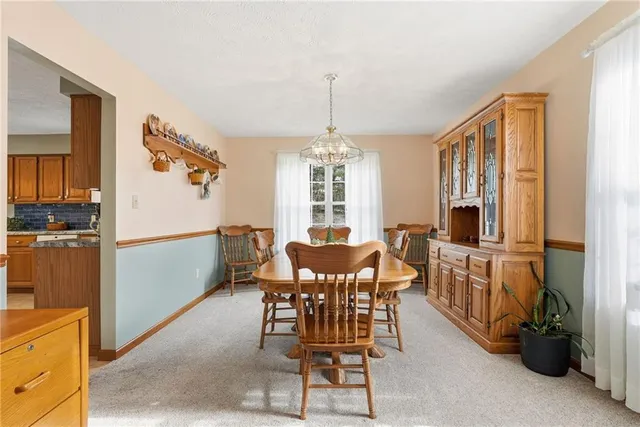 a view of a dining room with furniture and a chandelier