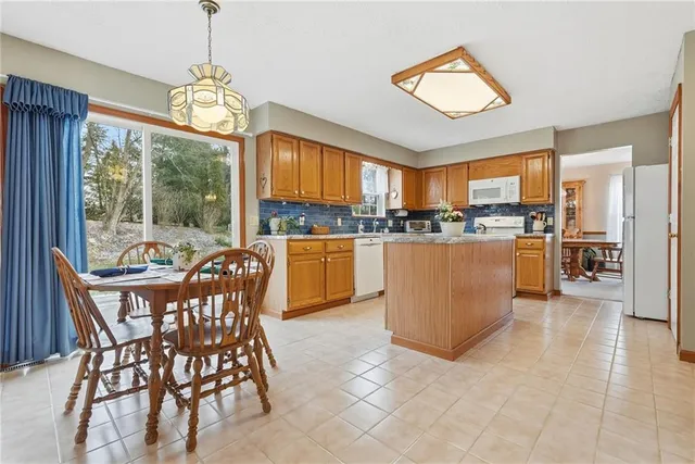 a view of a dining room with furniture a chandelier and kitchen view
