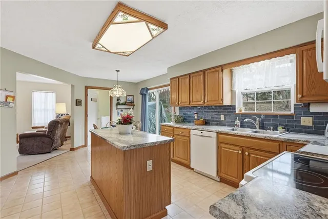 a kitchen with stainless steel appliances granite countertop a sink dishwasher stove and refrigerator