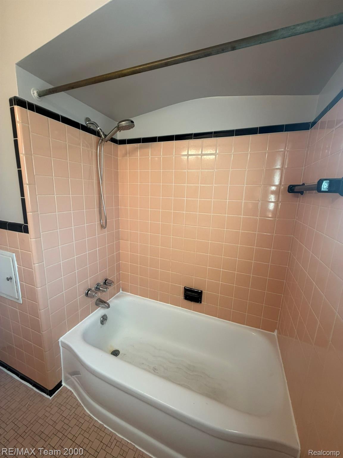 9023 Evergreen Road Detroit, MI 48228 - Photo 16 of 21 White bathtub with chrome fixtures, surrounded by pink square tiles with black trim